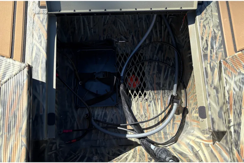 Slide: The Image of Interior view of 2027 Tracker Grizzly 1650 T Prairie Wings Edition boat with wiring and storage. - 16