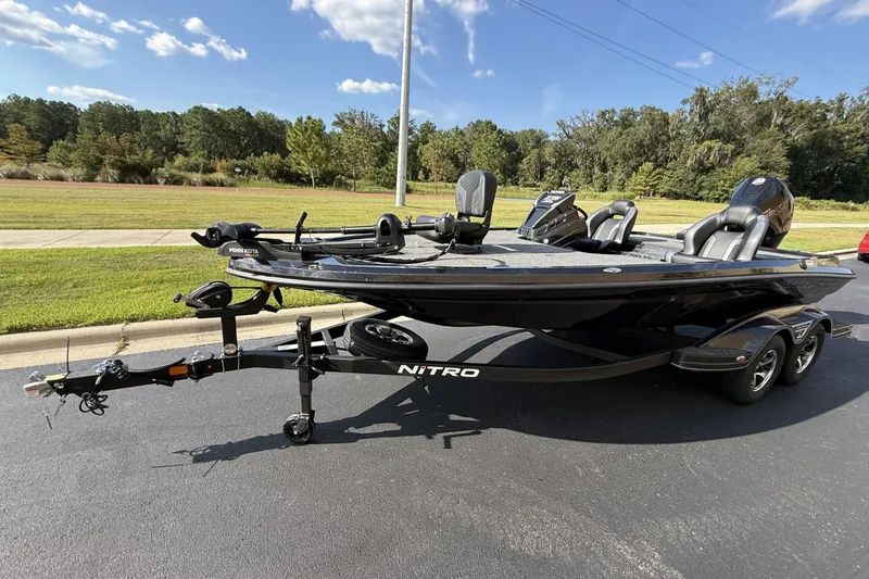 Slide: The Image of 2027 Nitro Z19 XL boat on trailer, parked on asphalt, with green landscape background. - 2