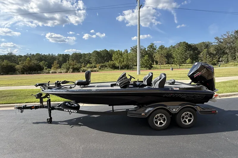 The Image of 2027 Nitro Z19 XL boat on trailer, parked on road with scenic background. - 0