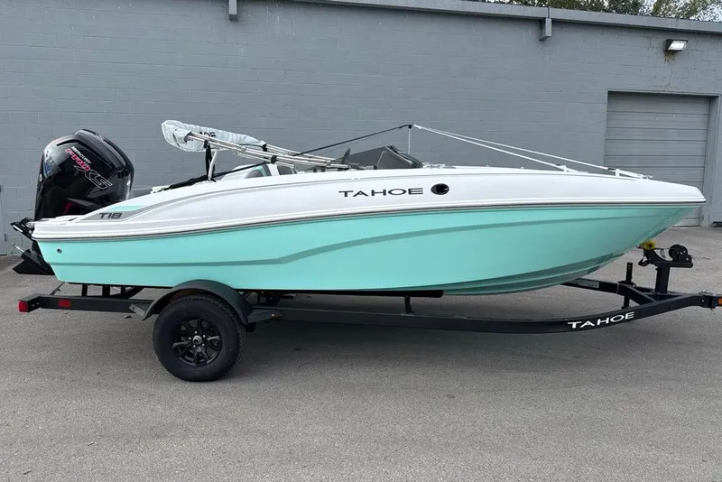 Slide: The Image of 2027 Tahoe T18 boat with outboard motor on trailer, light blue and white design. - 9