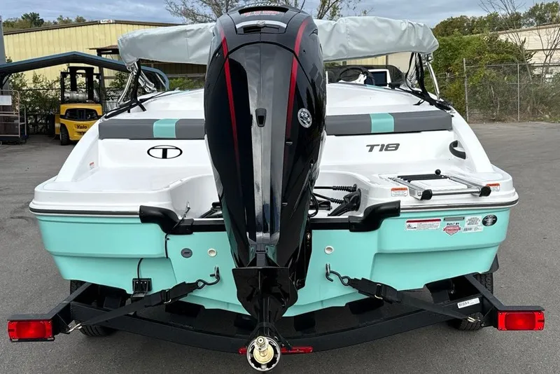 Slide: The Image of 2027 Tahoe T18 boat with outboard motor on trailer, parked outdoors. - 2