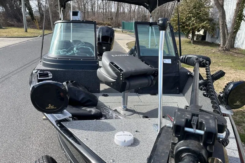 Slide: The Image of 2023 Lund 1650 Rebel XL Sport boat with seating and equipment on a road. - 4