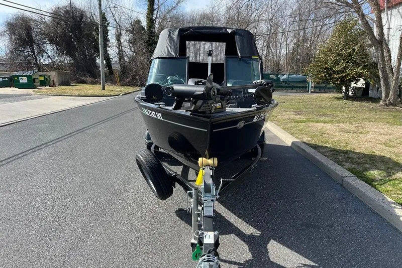 Slide: The Image of 2023 Lund 1650 Rebel XL Sport boat on trailer, parked on a road. - 2