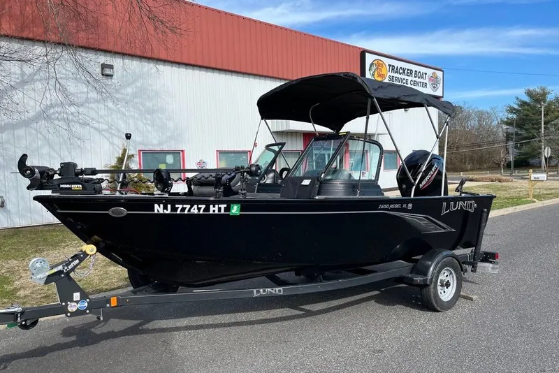 Slide: The Image of 2023 Lund 1650 Rebel XL Sport boat on trailer outside service center. - 1
