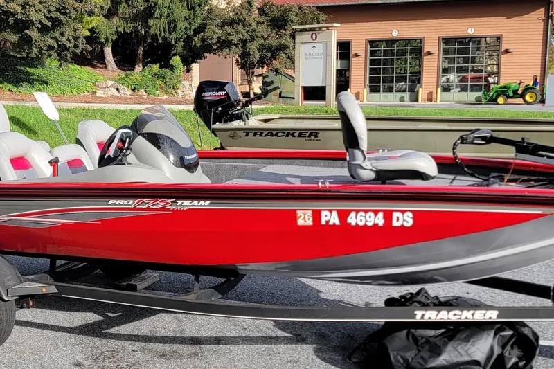 The Image of 2017 Tracker Pro Team 175 TXW boat in vibrant red, parked outdoors. - 0