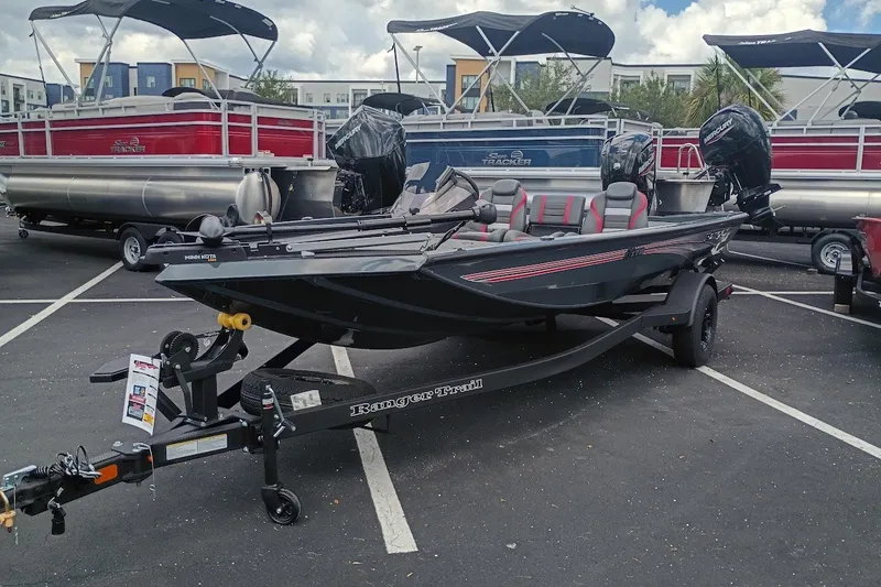 The Image of 2027 Ranger RT178 boat on trailer in parking lot, surrounded by pontoon boats. - 1