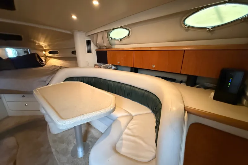 Slide: The Image of 1998 Wellcraft 3200 Martinique cabin interior with seating, table, and portholes. - 38