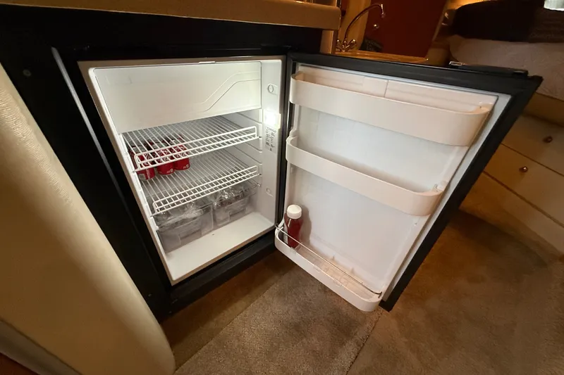 Slide: The Image of Open mini fridge inside 1998 Wellcraft 3200 Martinique boat, stocked with drinks and condiments. - 44