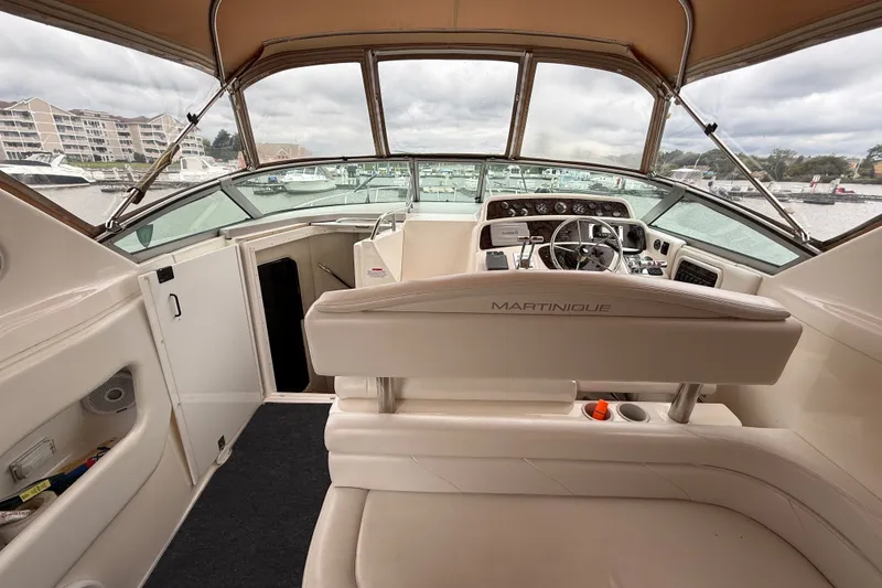 Slide: The Image of 1998 Wellcraft 3200 Martinique boat interior with helm, steering wheel, and marina view. - 17