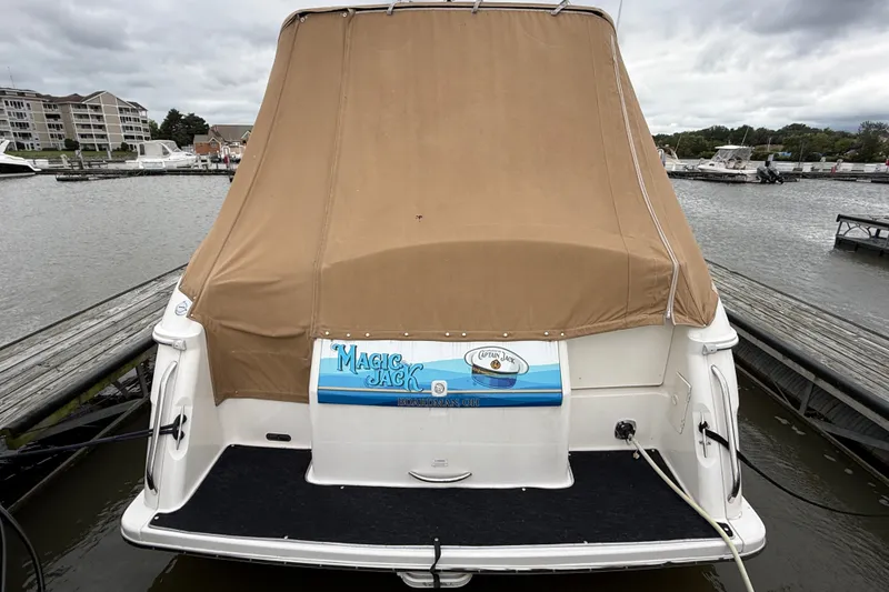 Slide: The Image of 1998 Wellcraft 3200 Martinique boat docked with tan cover, rear view. - 4