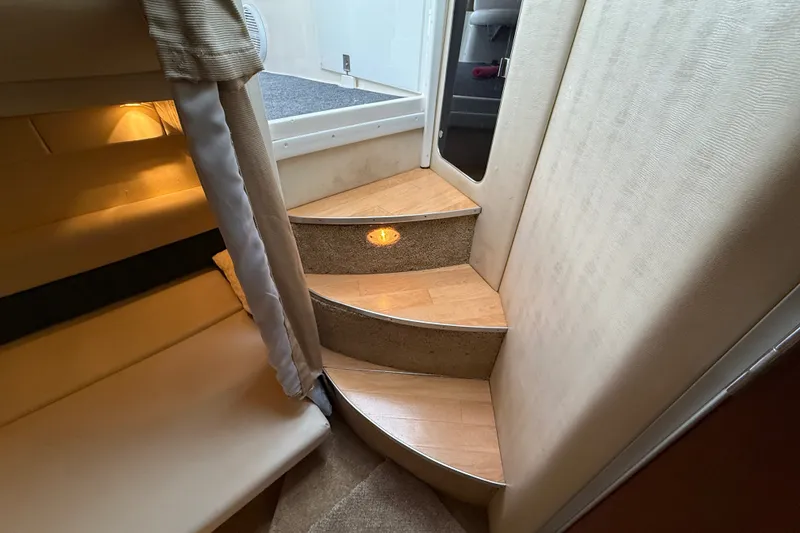 Slide: The Image of Interior stairs of a 1998 Wellcraft 3200 Martinique boat, featuring wood and carpet design. - 55
