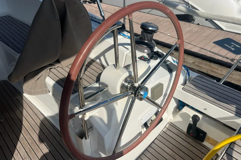 Slide: The Image of Steering wheel of a 2013 Jeanneau Sun Odyssey 44 DS sailboat, featuring teak decking. - 10