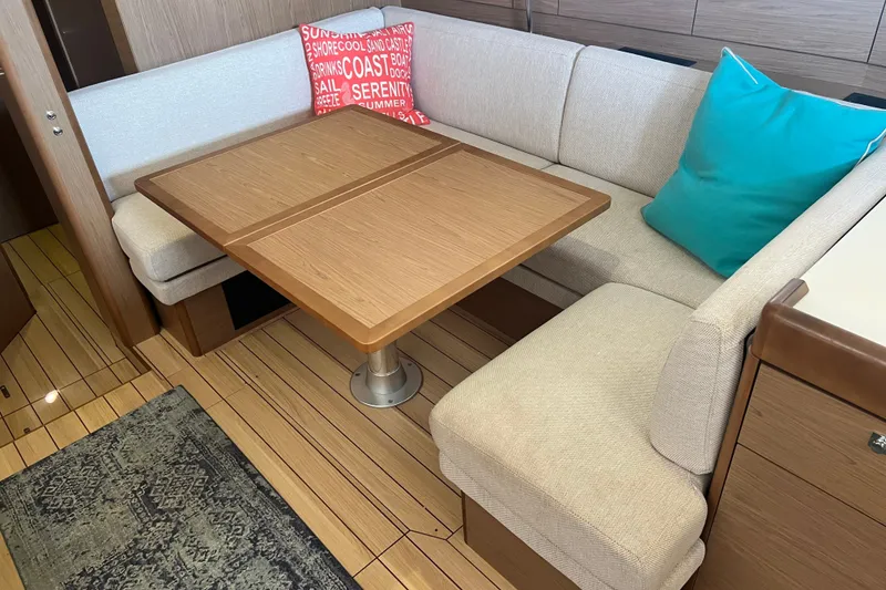 Slide: The Image of Cozy interior of 2013 Jeanneau Sun Odyssey 44 DS with wooden table and cushioned seating. - 26