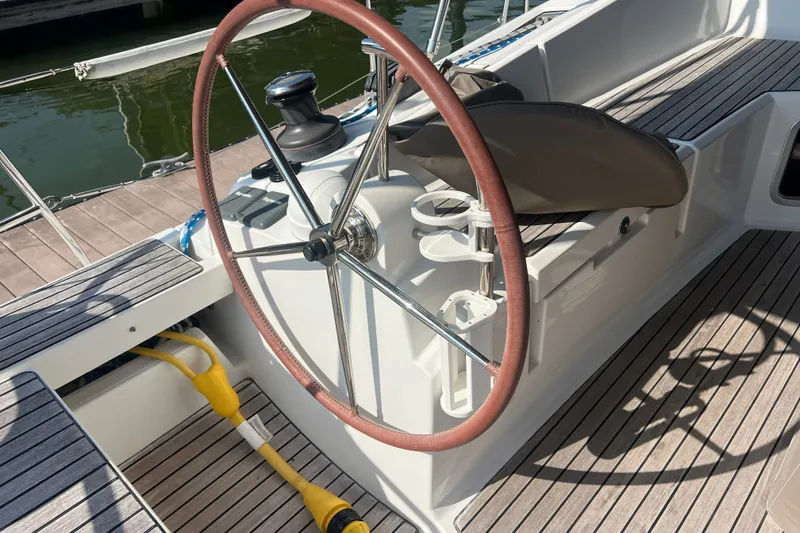 Slide: The Image of Steering wheel of 2013 Jeanneau Sun Odyssey 44 DS sailboat, docked with wooden deck. - 11