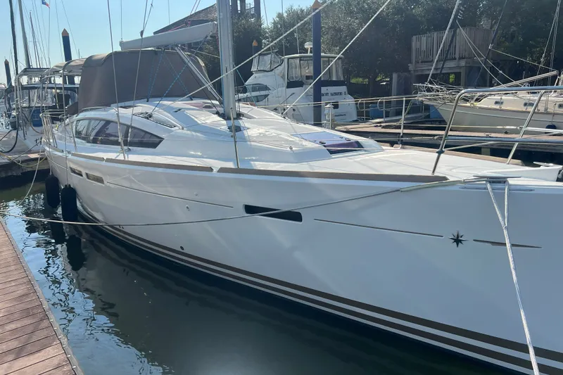 Slide: The Image of 2013 Jeanneau Sun Odyssey 44 DS sailboat docked at marina, showcasing sleek design. - 1