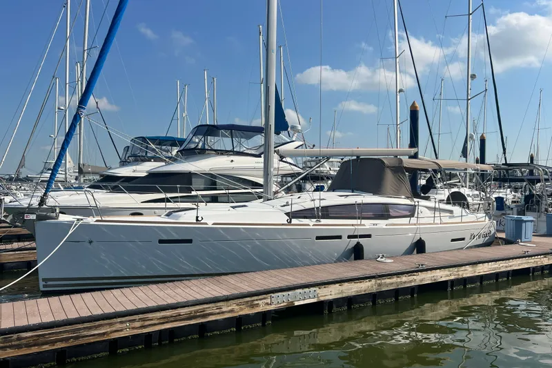 The Image of 2013 Jeanneau Sun Odyssey 44 DS yacht docked at marina under clear blue sky. - 0