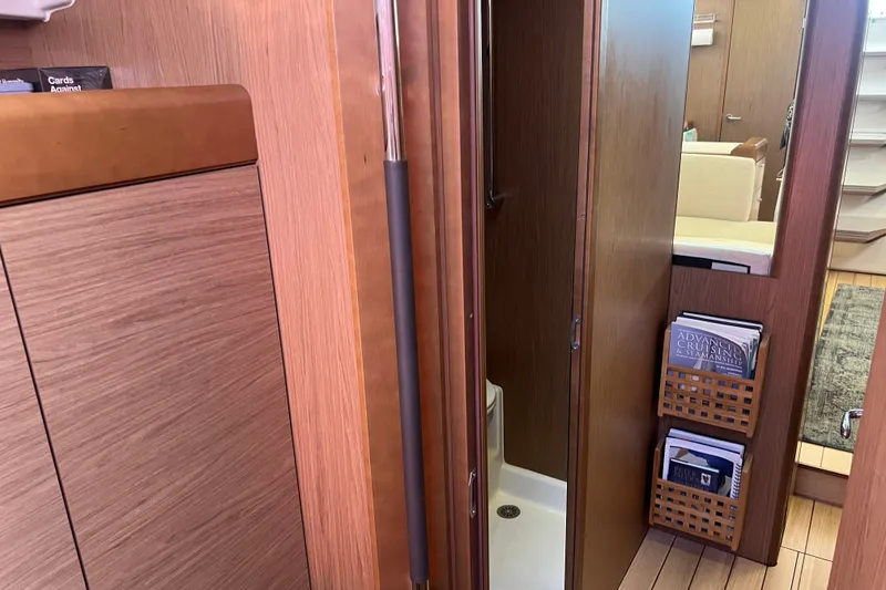 Slide: The Image of Interior of 2013 Jeanneau Sun Odyssey 44 DS yacht, featuring wooden cabinetry and a compact bathroom. - 24