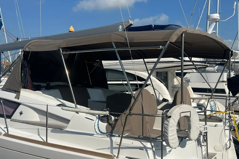 Slide: The Image of 2013 Jeanneau Sun Odyssey 44 DS sailboat with canopy, docked at marina under blue sky. - 4