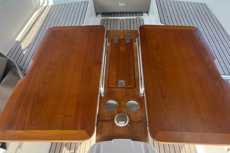 Slide: The Image of Teak cockpit table on 2013 Jeanneau Sun Odyssey 44 DS yacht, featuring stainless steel handrails. - 36