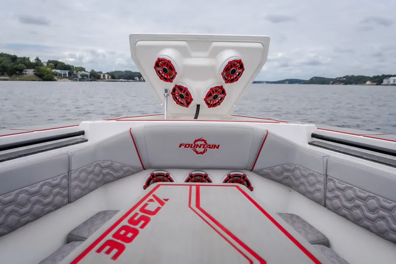Slide: The Image of 2024 Fountain 38 SCX boat interior with red accents and speakers on a lake. - 68