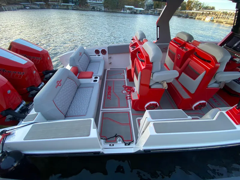 Slide: The Image of 2024 Fountain 38 SCX boat interior with red and white seating, docked by the water. - 11