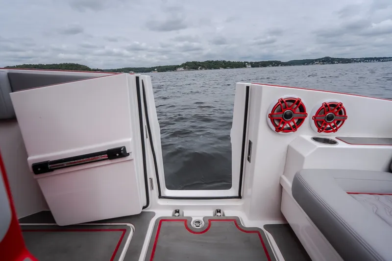 Slide: The Image of 2024 Fountain 38 SCX boat interior with open door, red speakers, and lake view. - 18