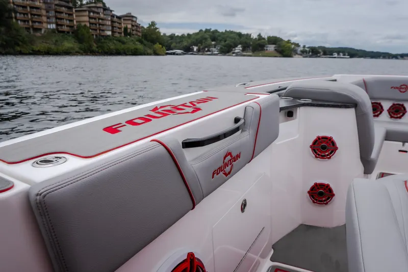 Slide: The Image of 2024 Fountain 38 SCX boat interior with branded seating and speakers on a scenic lake. - 82