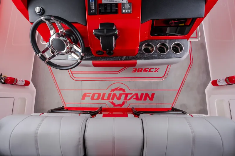 Slide: The Image of 2024 Fountain 38 SCX boat interior with red accents, steering wheel, and branded flooring. - 50