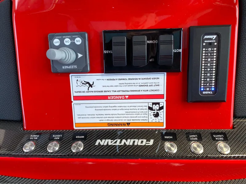 Slide: The Image of Control panel of 2024 Fountain 38 SCX boat with switches and warning labels. - 23