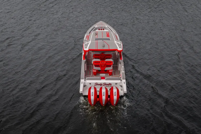 Slide: The Image of 2024 Fountain 38 SCX boat with red accents cruising on water. - 2
