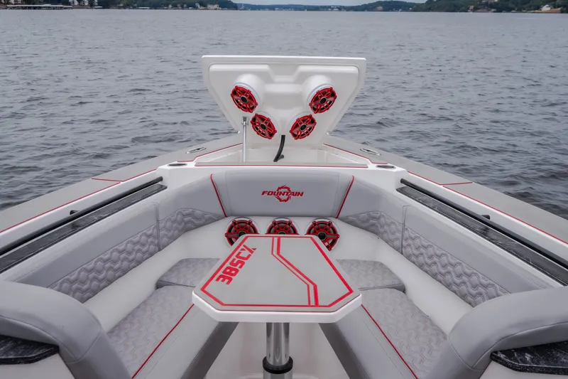 Slide: The Image of 2024 Fountain 38 SCX boat interior with seating and table on a lake. - 72