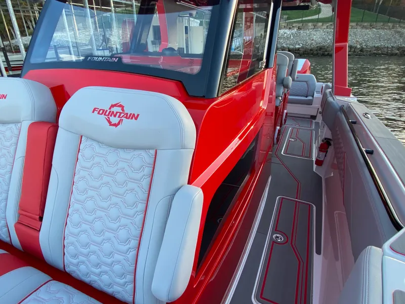 Slide: The Image of 2024 Fountain 38 SCX boat with red and white seating, docked by the water. - 20