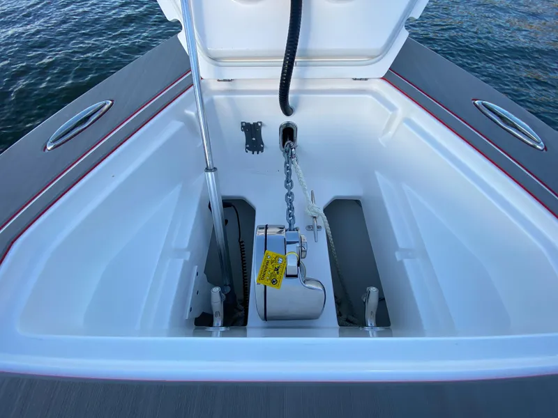 Slide: The Image of 2024 Fountain 38 SCX anchor compartment with chain and winch, open on calm water. - 31