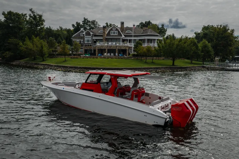 Slide: The Image of 2024 Fountain 38 SCX boat on water near a luxurious lakeside mansion. - 15