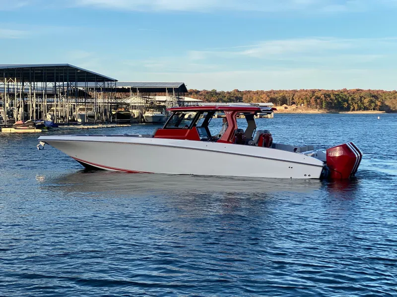 Slide: The Image of 2024 Fountain 38 SCX boat on a calm lake near a marina. - 5