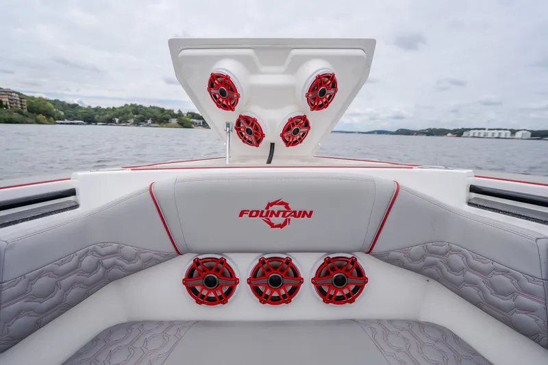 Slide: The Image of 2024 Fountain 38 SCX boat interior with red speakers and logo, on a scenic lake. - 69