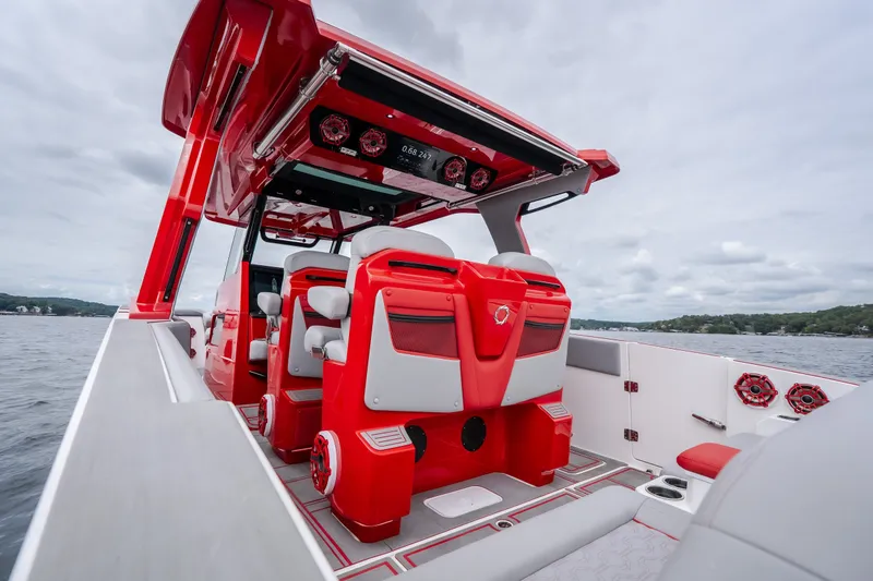 Slide: The Image of 2024 Fountain 38 SCX boat interior with red and white seating, on a cloudy day. - 26