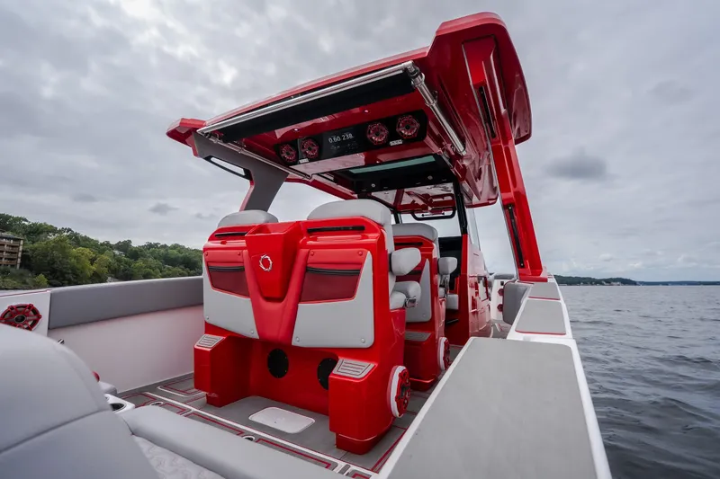 Slide: The Image of 2024 Fountain 38 SCX boat interior with red and white seating on a lake. - 27