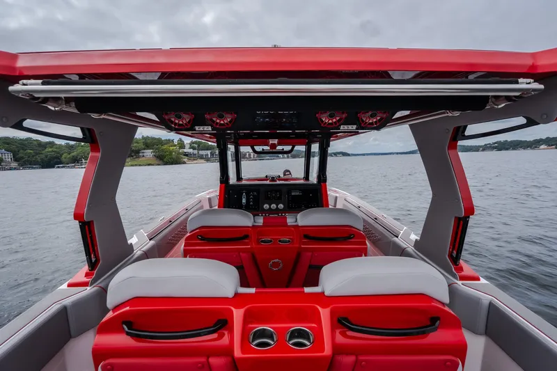 Slide: The Image of 2024 Fountain 38 SCX boat interior with red and white seating, on a calm lake. - 28