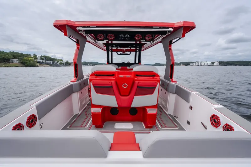 Slide: The Image of 2024 Fountain 38 SCX boat interior with red and gray seating on a lake. - 25