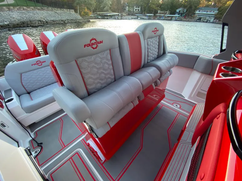 Slide: The Image of 2024 Fountain 38 SCX boat interior with red and gray seating by the water. - 13
