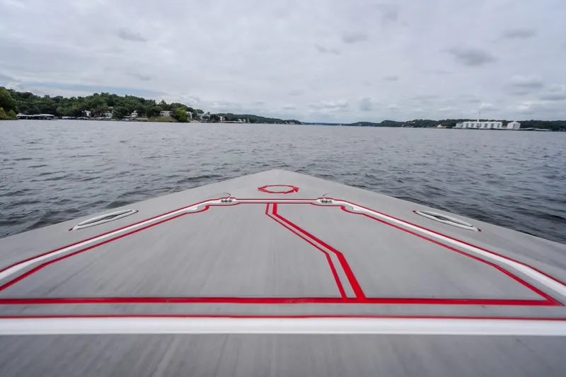 Slide: The Image of 2024 Fountain 38 SCX boat cruising on a calm lake under a cloudy sky. - 75