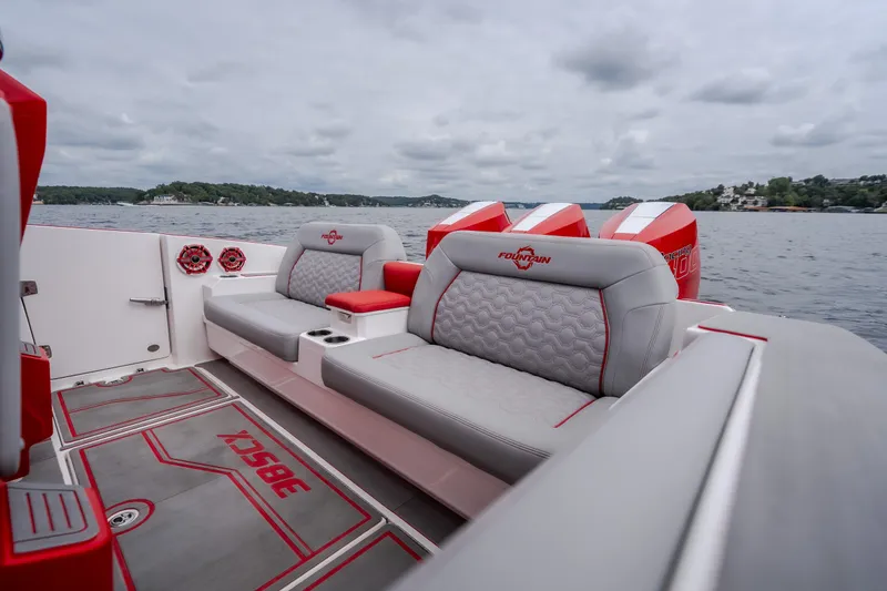 Slide: The Image of 2024 Fountain 38 SCX boat interior with gray and red seating, on a lake. - 23