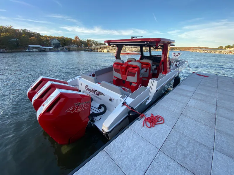 Slide: The Image of 2024 Fountain 38 SCX boat docked, featuring triple red outboard engines. - 8