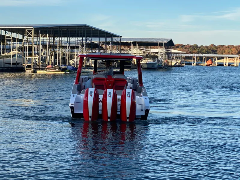 Slide: The Image of 2024 Fountain 38 SCX boat with red accents on a calm lake near docks. - 1