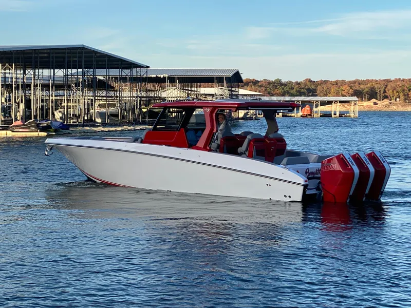 Slide: The Image of 2024 Fountain 38 SCX boat with red accents on a lake near a marina. - 19