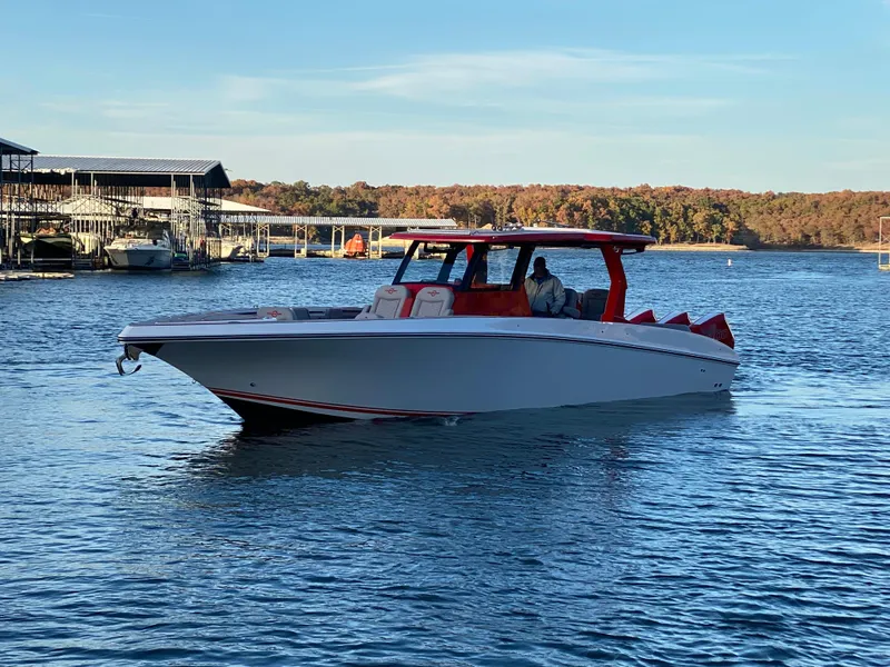 Slide: The Image of 2024 Fountain 38 SCX boat cruising on a lake with docks in the background. - 6