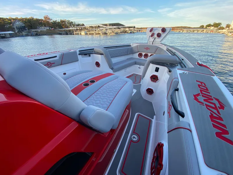 Slide: The Image of 2024 Fountain 38 SCX boat interior with red and gray seating, dockside view. - 29