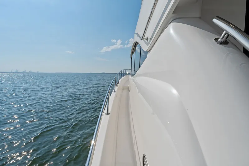 Slide: The Image of 2016 Maritimo M58 yacht cruising on open water under clear blue sky. - 12