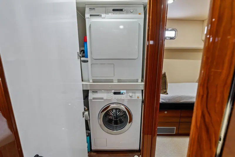 Slide: The Image of Laundry area with stacked washer and dryer in 2016 Maritimo M58 yacht. - 54